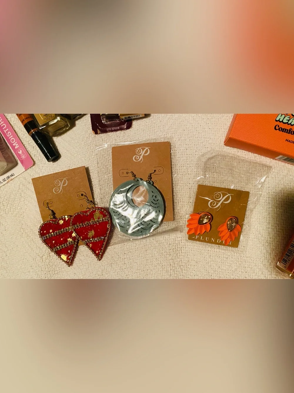 Bundle of Maybelline makeup assortment of earrings, skin care, nail polish